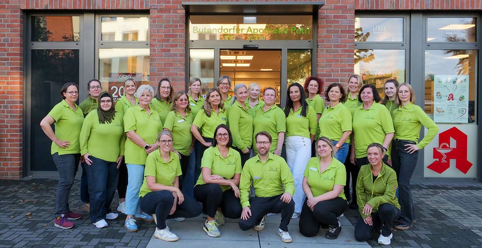 Gruppenfoto eines Teams der Butendorfer Apotheke Petri vor dem Eingang der Apotheke.